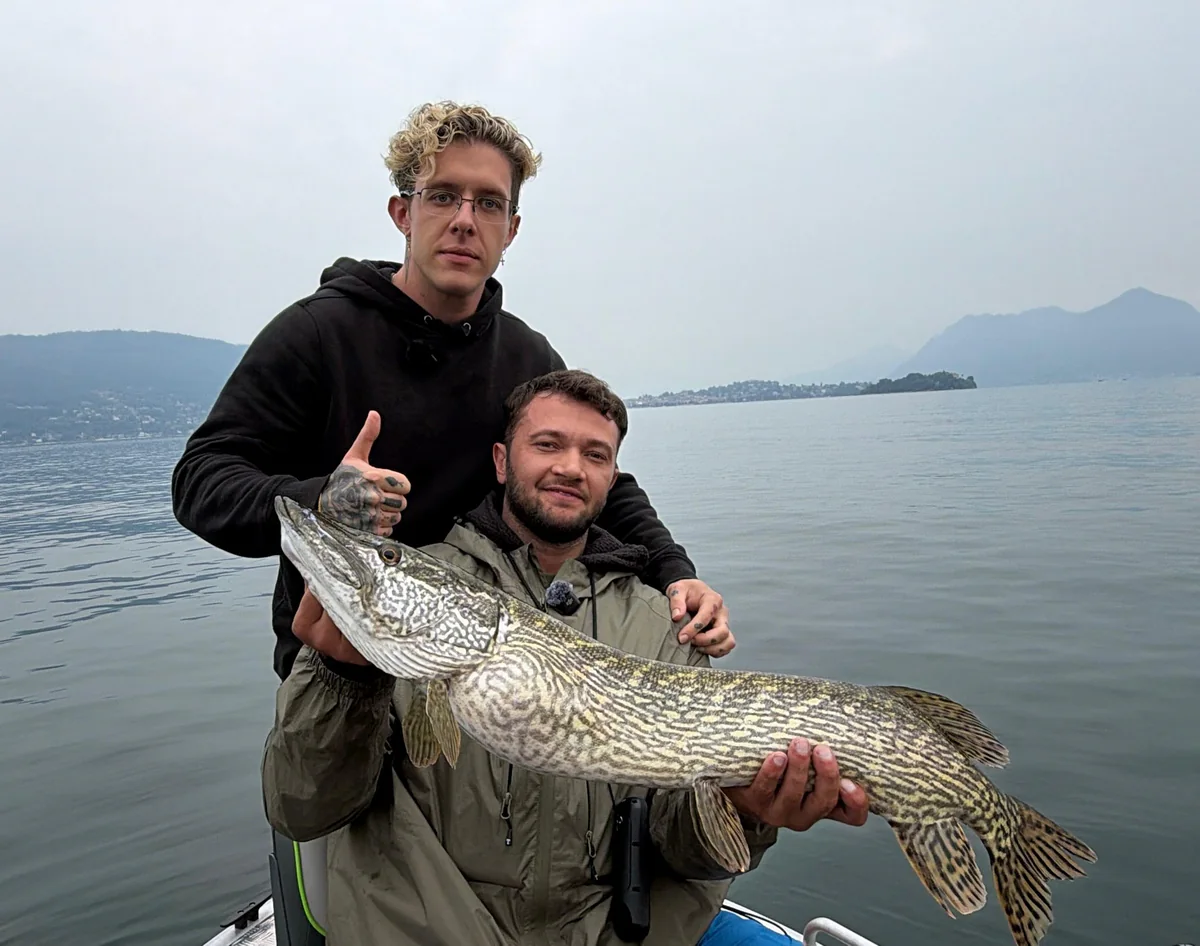 Manuel Bonetti con un luccio e un ospite a bordo, sul Lago Maggiore.